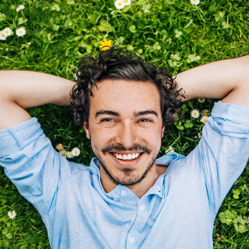 man smiling laying in grass